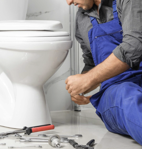 Plumber repairing a toilet